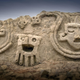 A section of the wall, showing two human heads and an “anthropomorphic” seed.